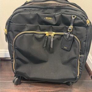 Tumi Black Rolling Travel Bag with Gold Hardware and Front Pocket